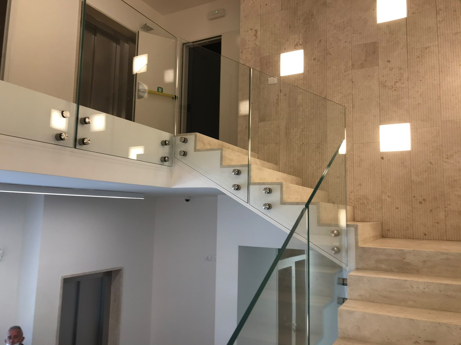 Scala interna in pietra chiara con parapetto in vetro dopo una ristrutturazione in Trexenta